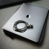 Azuro chrome earbuds coiled on a laptop in a sleeve